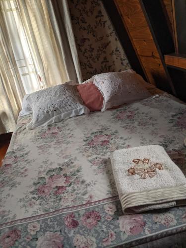 Habitación Boutique في Villa Alsina: سرير عليه غطاء من الزهور ومخدات