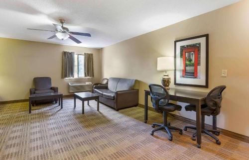 uma sala de estar com uma secretária e cadeiras em Extended Stay America Suites - Raleigh - Cary - Harrison Ave em Cary