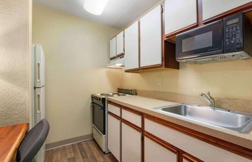una pequeña cocina con fregadero y microondas en Extended Stay America Suites - Fort Wayne - North, en Fort Wayne