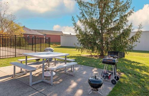 a picnic table with a grill and a grill at Extended Stay America Suites - Fort Wayne - North in Fort Wayne