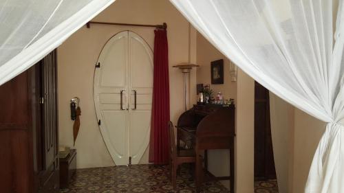 a room with a bed, a mirror, and a dresser at La Villa in Battambang