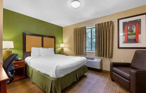 a hotel room with a bed and a chair at Extended Stay America Suites - Toledo - Maumee in Maumee
