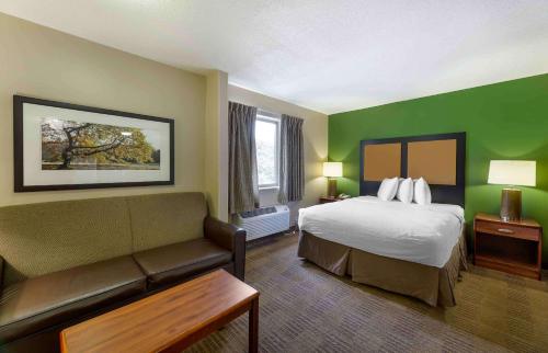 a hotel room with a bed and a couch at Extended Stay America Suites - Cleveland - Great Northern Mall in North Olmsted