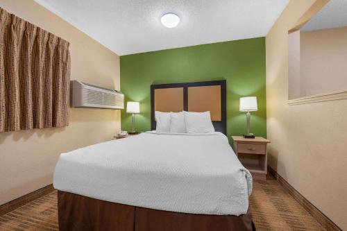 a large bed in a room with green walls at Extended Stay America Select Suites - Detroit - Warren in Warren