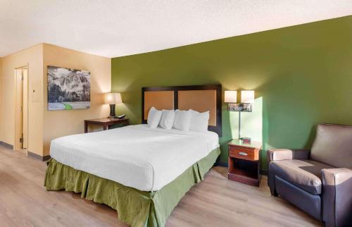 a bedroom with a large bed and a chair at Extended Stay America Suites - Los Angeles - Ontario Airport in Guasti