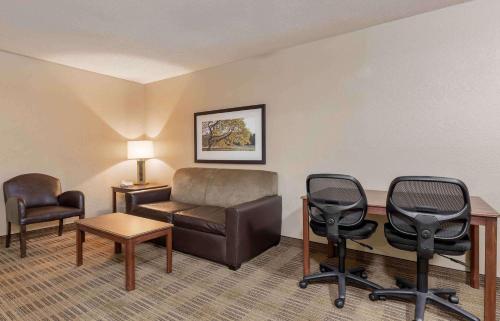 a room with a couch and chairs and a desk at Extended Stay America Select Suites - Detroit - Warren in Warren