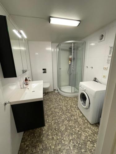 een badkamer met een wasmachine en een wasmachine bij Koselig og rolig leilighet med utsikt nær Preikestolen in Strand