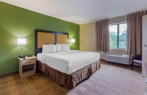 Extended Stay America Select Suites Tampa Airport Memorial Hwy في تامبا: غرفة فندقية بسرير كبير ونافذة