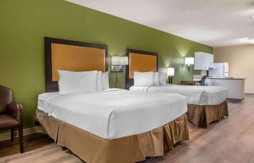 2 camas en una habitación de hotel con paredes verdes en Extended Stay America Suites - Minneapolis - Woodbury, en Woodbury