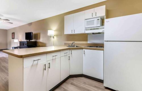 a kitchen with white cabinets and a white refrigerator at Extended Stay America Suites - Minneapolis - Woodbury in Woodbury