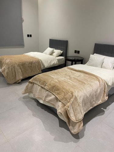 2 camas con mantas en una habitación en شقه ذات سقف مرتفع لغير المدخنين في النرجس en Riad