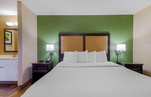 Un dormitorio con una cama grande y una pared verde en Extended Stay America Select Suites - Atlanta - Buckhead, en Atlanta