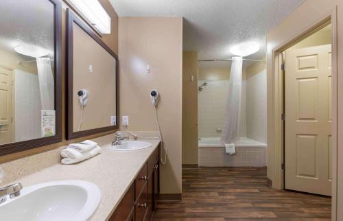 uma casa de banho com 2 lavatórios e um espelho grande em Extended Stay America Suites - Raleigh - RTP - 4919 Miami Blvd em Durham