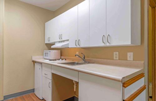 una cocina con armarios blancos y fregadero en Extended Stay America Select Suites - Atlanta - Marietta - Wildwood, en Atlanta