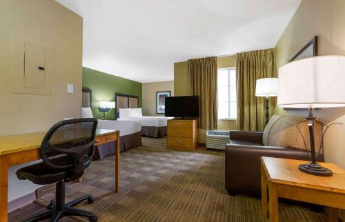 a hotel room with a desk and a room with two beds at Extended Stay America Select Suites - Atlanta - Perimeter - Peachtree Dunwoody in Atlanta
