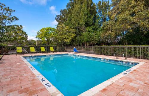 a swimming pool with chairs and a fence at Extended Stay America Select Suites - Atlanta - Perimeter - Peachtree Dunwoody in Atlanta