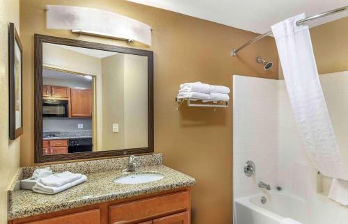 a bathroom with a sink and a mirror and a tub at Extended Stay America Suites - Bakersfield - Chester Lane in Bakersfield
