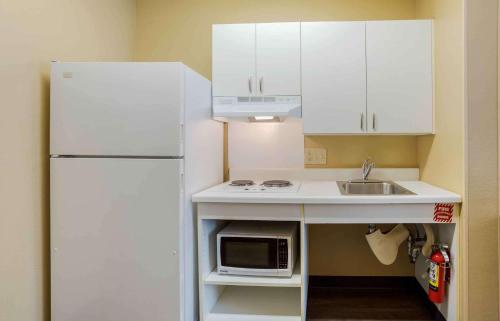 a small kitchen with a white refrigerator and a sink at Extended Stay America Select Suites - Destin - US 98 - Emerald Coast Pkwy in Destin