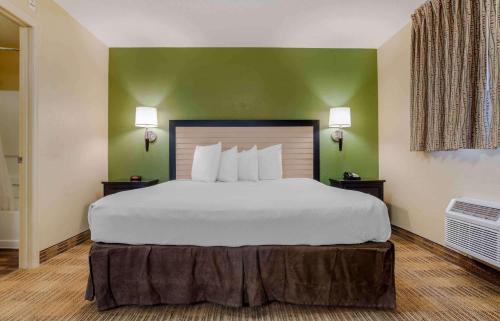 uma cama grande num quarto de hotel com paredes verdes em Extended Stay America Suites - Destin - US 98 - Emerald Coast Pkwy em Destin