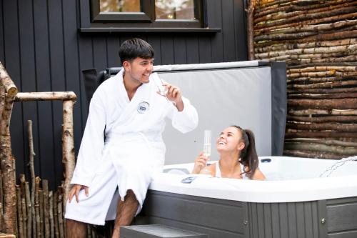 a man and a woman in a bath tub at The Mar Huts - The Conic Hut in Drymen