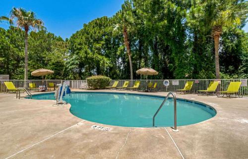 una piscina con sillas y sombrillas en Extended Stay America Suites - Destin - US 98 - Emerald Coast Pkwy en Destin