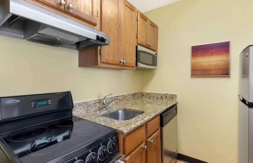 a small kitchen with a stove and a sink at Extended Stay America Suites - Richmond - Glen Allen - Short Pump in Glen Allen
