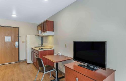 a living room with a television and a desk with a chair at Extended Stay America Select Suites - Little Rock - Southwest in Little Rock