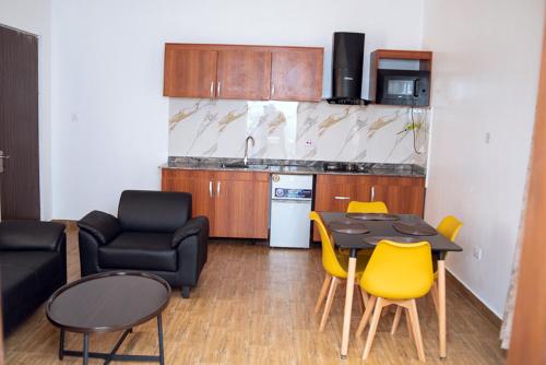 een woonkamer met een tafel en stoelen en een keuken bij 1 Bedroom Bungalow in Alalubosa GRA in Ibadan