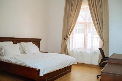 ein Schlafzimmer mit einem Bett und einem großen Fenster in der Unterkunft 1 Bedroom Bungalow in Alalubosa GRA in Ibadan