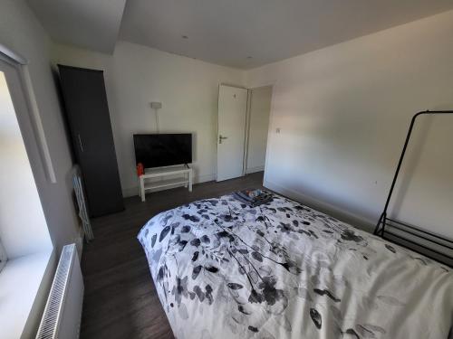 a bedroom with a bed and a flat screen tv at Cozy Private Room Close Central Ideal Location in London