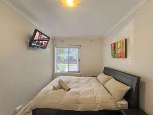 Cama pequeña en habitación con ventana en Ground floor one bedroom apartment in Elsternwick, en Melbourne