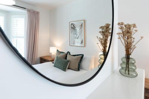 - un miroir réfléchissant le lit dans la chambre dans l'établissement Central Elegance: Cottage Gem with Parking, à Launceston