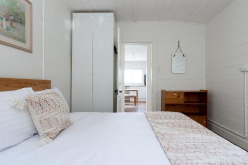 um quarto com uma grande cama branca e uma colcha branca em What a Charmer: Near the CBD Parking & Wifi em Launceston