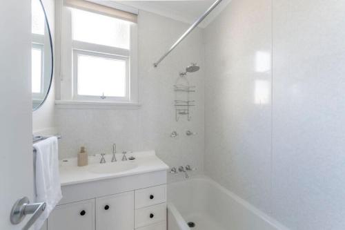 a white bathroom with a sink and a shower at Sea You Soon: Views Parking & WiFi in Burnie