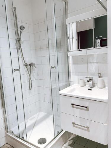 a white bathroom with a shower and a sink at Zentrales Apartment nähe Schönbrunn - 2 Pers in Vienna