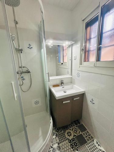 une salle de bain blanche avec un lavabo et une douche dans l'établissement BISCAROSSE PLAGE STUDIO TERASSE BARBECUE À 150 m DE LA PLAGE, à Biscarrosse