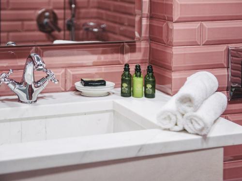 a bathroom sink with towels and bottles of wine at Its Kale Boutique Hotel in Ioannina