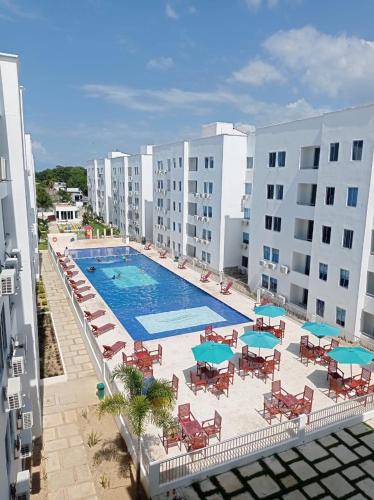 Hermosos apartamentos en caribe campestre, coveñas في كوفيناس: اطلالة علوية على مسبح مع كراسي ومظلات