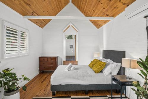 a bedroom with a bed and a wooden ceiling at Duck Walk Cottage - Boutique Studio Retreat in Burradoo