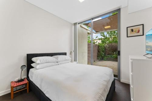 a bedroom with a large white bed and a window at Tranquil 1-Bed Apartment with Courtyard, Pool, BBQ in Phillip
