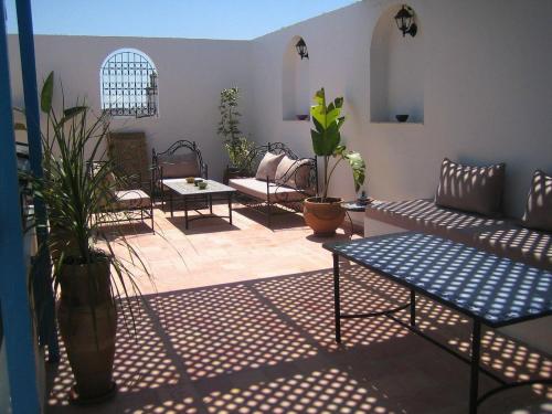 a living room with couches and tables and potted plants at Riad Dar Souika in Rabat