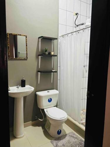 een badkamer met een toilet, een wastafel en een douche bij Casa moderna en catacamas in Catacamas