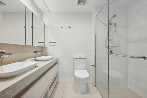 uma casa de banho com um lavatório, um WC e um chuveiro em 3-Bed Luxurious Retreat by Brisbane River & CBD em Brisbane