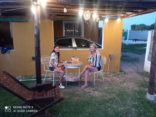 duas mulheres sentadas numa mesa num pátio em CÁBAÑAs , S,E,2 em Villa Los Aromos