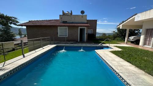 - une piscine en face d'une maison dans l'établissement Casa vista panorámica al lago, à Córdoba