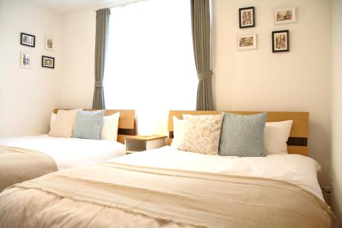 um quarto com 2 camas e uma janela em Casa Stella 2 Capricorn by Liaison em Osaka