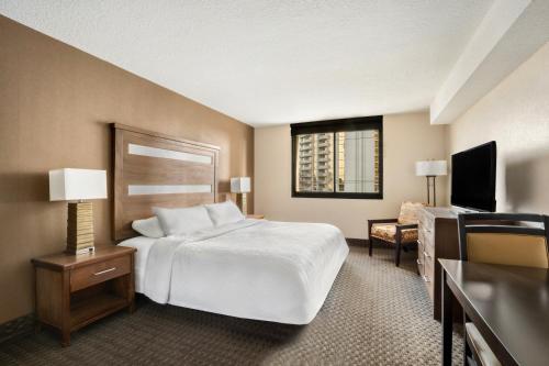 a hotel room with a bed and a television at The Carriage House in Las Vegas