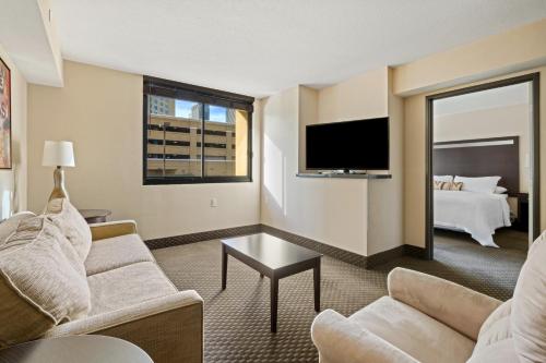 a living room with a couch and a tv and a bed at The Carriage House in Las Vegas