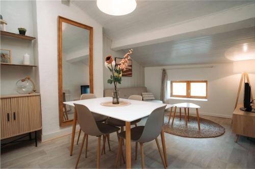 une salle à manger avec une table et des chaises blanches dans l'établissement Appartement centre Puy-en-Velay, au Puy-en-Velay