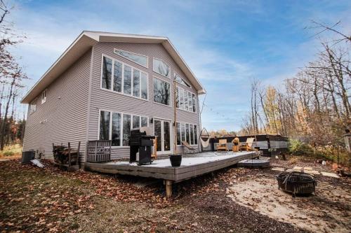 a large house with a porch on a yard at Modern Home of Style & Comfort! in Petoskey